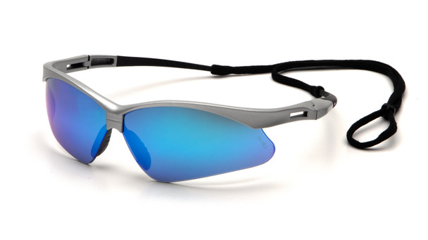 A detailed 3/4 view of the Pyramex PMXTREME SS6365SP safety glasses, featuring a sleek metallic silver frame and a vibrant ice blue mirror lens. The blue mirror coating is specifically engineered for bright outdoor sunlight, offering superior glare reduction and 99% protection against harmful UVA, UVB, and UVC rays. This model utilizes the signature PMXTREME 10-base curve panoramic lens design to ensure a wide, unobstructed field of vision and total wraparound side protection. Ergonomic features include ventilated straight-back silver temples for airflow and a built-in rubber nose piece for a secure, non-slip fit during physical activity. Weighing just 23.1 grams, these glasses are ANSI Z87.1-2020 high-impact certified and come with an included black lanyard cord for added security on the job.