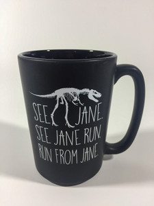 Black matte 12 oz ceramic mug imprinted in white fossil sandwiched between the text “ See Jane, See Jane Run, Run from Jane”.  With the Carnegie Museum of Natural History logo on the side.