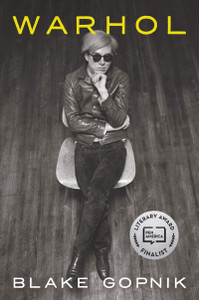 A black and white photos of a seated Andy Warhol taken from above A black and white photos of a seated Andy Warhol taken from above