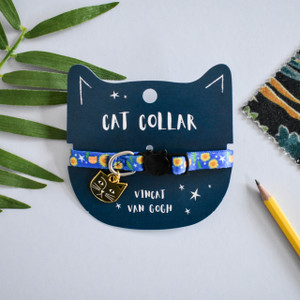 Bright blue cat collar featuring sunflowers, stars, and a brown cat with one ear. Cat- shaped metal charm and black buckle. Bright blue cat collar featuring sunflowers, stars, and a brown cat with one ear. Cat- shaped metal charm and black buckle.
