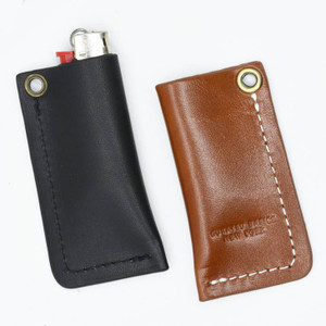 Two leather lighter cases next to each other, one black and one brown. Two leather lighter cases next to each other, one black and one brown.