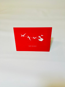 5x7 red card with T-Rex skeleton in sleigh with pterosaurs flighting in white.