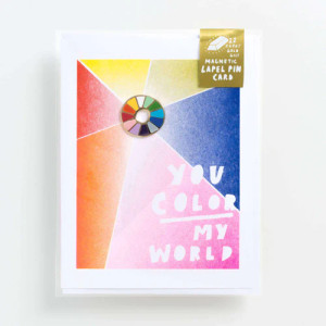 a colorful notecard, text: You color my world,  with an enamel pin.