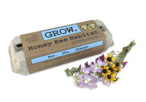 egg carton with "GROW' written on blue box, small bouquet of flowers next to carton egg carton with "GROW' written on blue box, small bouquet of flowers next to carton