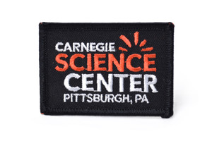 A black iron-on patch featuring the logo for the Carnegie Science Center