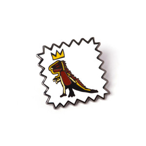 Close up of the T-rex wearing a crown enamel pin. Close up of the T-rex wearing a crown enamel pin.