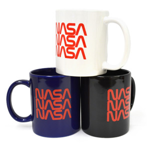 A white mug with the NASA worm logo in three red rows sitting atop a dark blue mug with the NASA worm logo in three red rows and a black mug with the NASA worm logo in three red rows