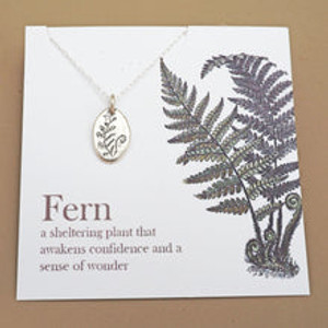 shows silver necklace with silver amulet engraved with a fern on white backing card with a larger fern image on it shows silver necklace with silver amulet engraved with a fern on white backing card with a larger fern image on it