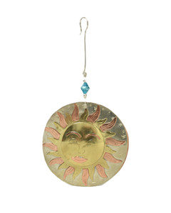 A round metal ornament with the sun imprinted