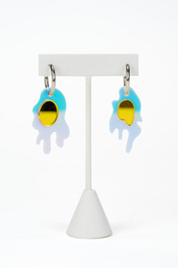 Breakfast egg hoop earrings on an earring display.
