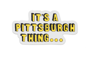 A hand holding a white sticker with yellow lettering, text "it's a Pittsburgh thing..." A hand holding a white sticker with yellow lettering, text "it's a Pittsburgh thing..."