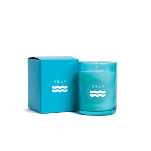 candle and outer packaging. both are a light teal color with the word "kelp" printed across the front and a squiggly equals sign under the word. candle and outer packaging. both are a light teal color with the word "kelp" printed across the front and a squiggly equals sign under the word.