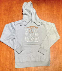 hoodie laid flat against wood background, hoodie is a pale blue-green with a brown 2D image of a nanotyrannus fossil and the words "see jane, see jane run, run from jane" written in 3 separate lines beneath