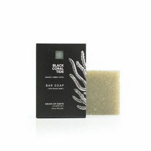 outer packaging of soap and the soap itself, packaging is black with white coral imagery on the right hand side, soap is a square, speckled gray/green color outer packaging of soap and the soap itself, packaging is black with white coral imagery on the right hand side, soap is a square, speckled gray/green color