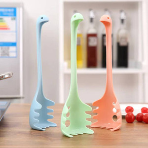 three dino shaped noodle spoons sitting upright on a counter three dino shaped noodle spoons sitting upright on a counter