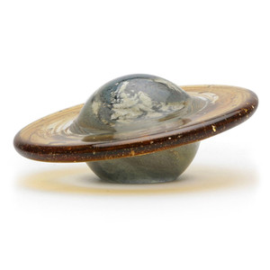 A spherical paperweight with a made with swirls of colored glass and a tilted glass ring to resemble the planet Saturn A spherical paperweight with a made with swirls of colored glass and a tilted glass ring to resemble the planet Saturn