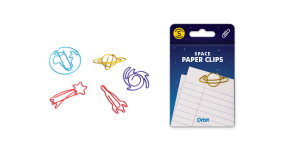 Five space-themed paper clips in bright colors next to their packaging