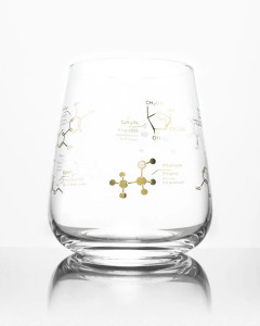 A stemless wine glass with gold imprints of various molecules found in wine