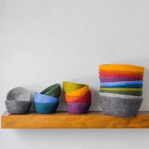 all colors of bowls, stacked on a shelf