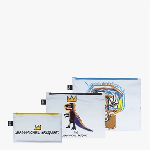 set of three reflective zippered rectangular bags, in three different sizes. Each has an image of Basquiat's art work.