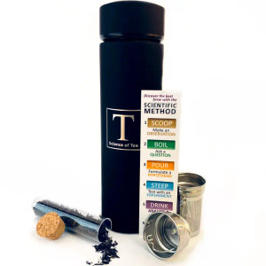 A black drink tumbler with its double basket infuser, a test tube of black tea, and instructions