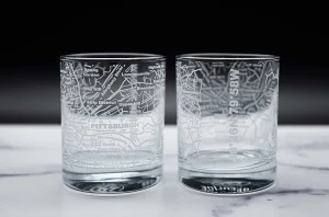 A pair of whiskey glasses etched with a Pittsburgh Street map