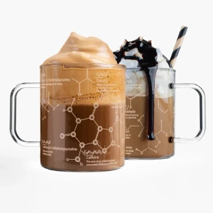 Two glass mugs etched with models of molecules found in coffee full of hot drinks with whipped cream and foam
