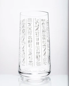 An image showcasing the glass. It is clear, tubular, with white foil hieroglyphics covering it.