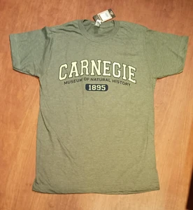 An image of  the tee. It is a pistachio green, with the name "CARNEGIE" in collegiate style lettering in lighter green. Below this is "Museum of Natural History" in black, with "1895" in white over a black a rounded-edge rectangle.