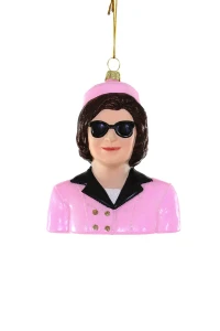 Glass ornament of a Jackie Kennedy bust, pink jacket and hat.