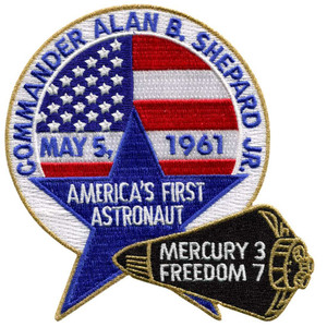This image shows a patch with Commander Alan Shepard around the top of the circle.   It has May 5, 1961 as the date on it, and says he is America's first astronaut. This image shows a patch with Commander Alan Shepard around the top of the circle.   It has May 5, 1961 as the date on it, and says he is America's first astronaut.