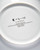 The white back of a round plate with  text . The white back of a round plate with  text .