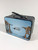 The black metal lunch box features the back wrap of the T.Rex skeletons head to head decal with the Carnegie Museum of Natural History logo in the center on a light blue background.