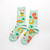 Mint green socks featuring lucky cats, dice, four leaf clovers, horseshoes, and rainbows.
