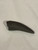 An image of the T.rex maxillary tooth replica. Dark in color, this measures 5 inches long, and is two inches wide at its base.