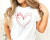 A woman wearing a white t-shirt that says "I Heart Science" in red with the word "heart" being replaced by an illustration of a heart shape
