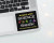 A black vinyl stickers with the words "Armed with Science & Snark You have been warned" in black a nd yellow and multicolored illustrations of scientific symbols and tools on the bottom right corner of an open laptop  below the keyboard
