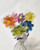 Daisy lollipops in orange, pink, purple, yellow, green and blue, arranged in a bouquet.