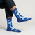 Abstract socks featuring monochrome blue palette inspired by Picasso’s Blue Period. Photographed worn on feet, styled with dark skinny jeans.