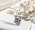 A chain pendant featuring a meteorite set in sterling silver shown on a white tablecloth with flowers