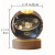 A crystal sphere lamp with the solar system engraved in the interior on a wooden USB powered base with measurements