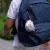 Keychain, orange cat in astronaut suit, plush toy. Photographed hanging from a backpack zipper.