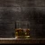 A partially whisky glass with the 8 planets of the Solar System etched into it on a table