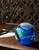 A glass paperweight made to look like the Earth on a table