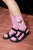 A person wearing the pink socks in black strappy sandals.