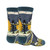 An image of the socks. The toe, heel, and cuff are a dusty blue gray. The upper half of the sock features a green stegosaurus in front of a yellow sun and pine trees. The text "Wild and Free" is below this. The lower half of the sock features a green long neck dinosaur and another stegosaurus over a lighter shade of blue-gray.