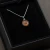 A pendant with martian meteor dust contained in glass against a red background in a black gift box