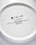 The white back of a round plate with  text . The white back of a round plate with  text .