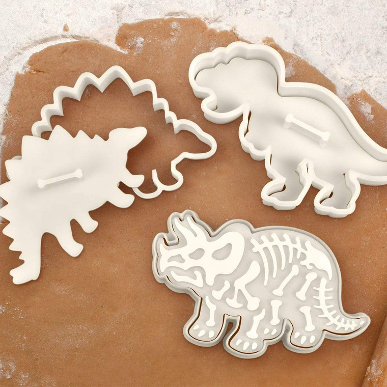Three dinosaur shaped cookie cutters, with skeleton stamp.