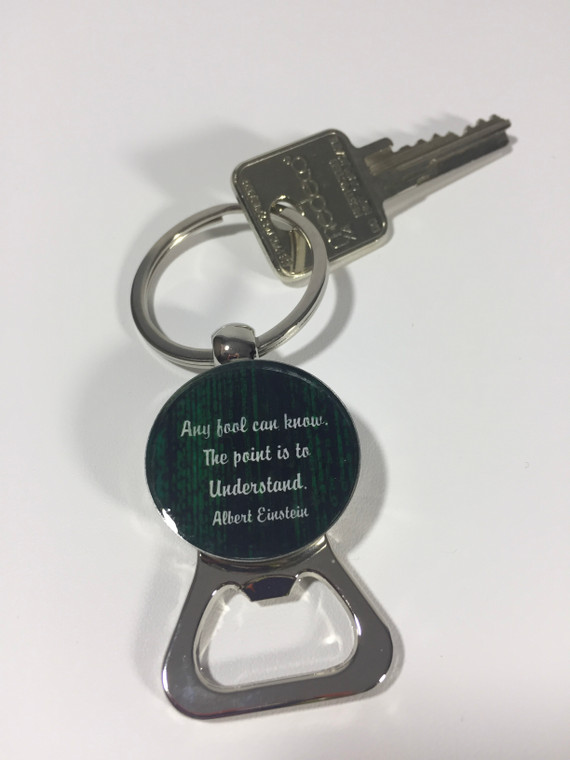 This image shows a silver metal keychain with a ring for keys on one end, and a silver bottle opener on the other end.  The middle is circle with an Einstein image on one side and his quote "Any fool can know, the point is to understand".